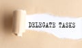 The text DELEGATE TASKS appears on torn paper on white background