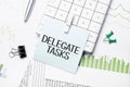 text delegate tasks. Written words on paper notebook . workplace. Business concept