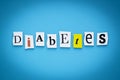 Text - diabetes. Single word. Cut paper letters on blue background. Writing on card. Inscription, message on banner