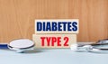 The text of the DIABETES TYPE 2 on wooden blocks and a stethoscope on the desktop. Clinic and medical business