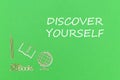 Text discover yourself, school supplies wooden miniatures on green background Royalty Free Stock Photo