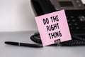 The text Do the right thinge written on a pink sticky note to remind you an important event. Closeup of personal agenda