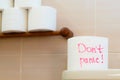 Text- Don't panic on the toilet paper. A roll of toilet paper on the background of several rolls