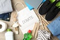 Text Donate clothes and different accessories on wooden background, top view