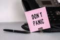 The text DonT Panic written on a pink sticky note to remind you an important event. Closeup of a personal agenda Royalty Free Stock Photo