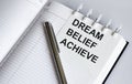 Text DREAM BELIEF ACHIEVE on the short note texture background with pen. Business concept Royalty Free Stock Photo