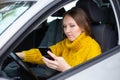 Text and drive woman. A woman is texting on her phone while driving