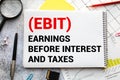 text Earnings Before Interest and Taxes EBIT on white paper.