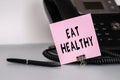 The text Eat Healthy written on a pink sticky note to remind you an important event. Closeup of a personal agenda Royalty Free Stock Photo