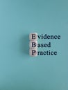 Text EBP Evidence-based practice concept on wooden cubes. Beautiful blue background.