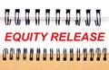 Text EQUITY RELEASE on white paper between white and brown spiral notepads Royalty Free Stock Photo