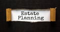 The text `estate planning` appearing behind torn black paper. Business concept