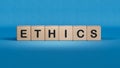 Text ETHICS on white notepad with cube block, stock concept.