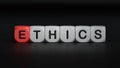 Text ETHICS on white notepad with cube block, stock concept.