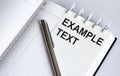 Text EXAMPLE TEXT on the short note texture background with pen Royalty Free Stock Photo