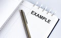 Text EXAMPLE on the short note texture background with pen Royalty Free Stock Photo
