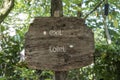 Text exit and toilet on a wooden board in a rainforest jungle of tropical Bali island, Indonesia. Exit and toilet wooden sign