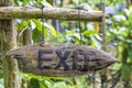 Text exit on a wooden board in a rainforest jungle of tropical Bali island, Indonesia. Exit wooden sign inscription in the asian