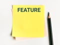 Text FEATURE written on sticky note.