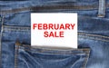 Text February Sale on white paper in the pocket of blue denim jeans