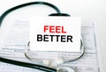 Text Feel Better on the white card with the stethoscope and medical documents Royalty Free Stock Photo