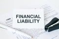 Text Financial Liability on note paper with white pen and stapler Royalty Free Stock Photo