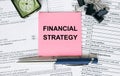 Text Financial Strategy on note paper with pen, compass and paper clips Royalty Free Stock Photo