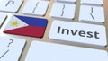 INVEST text and flag of Philippines on the buttons on the computer keyboard. Business related conceptual 3D rendering Royalty Free Stock Photo