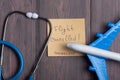 Text flights cancelled Coronavirus on sticky note, stethoscope and airplane model on wooden background