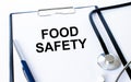 Text Food Safety on a sheet in the medical folder with a phonendoscope and pen