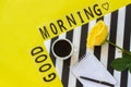 Text Good morning, coffee, yellow rose, notebook for text on stylish black and white napkin on yellow background. Minimal style