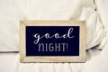 Text good night in a chalkboard on a bed