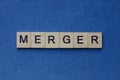 text on gray word merger in small wooden letters