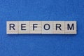 Text on gray word reform of small wooden letters