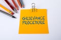 Text GRIEVANCE PROCEDURE on yellow piece of paper. White office desk Royalty Free Stock Photo