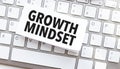 Text growth mindset written on paper sheet on a computer keyboard