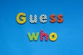 text guess who from bright colored paper letters on blue paper background.