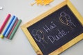 Text hai dude on the chalkboard and colorful chalk,autumn leaf origami. White background