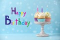 Text Happy Birthday and delicious cupcakes with candles on blue background Royalty Free Stock Photo