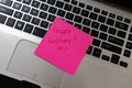 Text Happy Birthday on note. Pink sticky note on keyboard