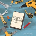 Text Happy Fathers Day writing in notebook lay on blue mechanic wooden desk with yellow home repair tools
