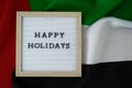 Text HAPPY HOLIDAYS on background waving flag of UAE. Independence Commemoration Day Muslim, Ramadan, Day of flag Royalty Free Stock Photo