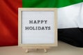 Text HAPPY HOLIDAYS on background waving flag of UAE. Independence Commemoration Day Muslim, Ramadan, Day of flag Royalty Free Stock Photo