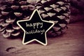 text happy holidays in a star-shaped blackboard, in black and white Royalty Free Stock Photo