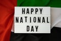 Text HAPPY NATIONAL DAY on background waving flag of UAE. National holiday of United Arab Emirates. Commemoration Day Royalty Free Stock Photo