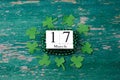 Text happy St. PAtrick`s Day and green clover ornament and with wooden blocks. Patric`s postcard design.