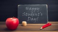 the text happy students day written in a chalkboard, placed on a rustic wooden school. generative ai Royalty Free Stock Photo