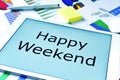 Text happy weekend in the screen of a tablet Royalty Free Stock Photo