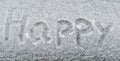 Text Happy in the white snow. Handwriting the word Happy in the snow. Snow background texture and cold winter concept