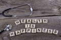 Text: HEALTH IS HAPPINESS from wooden letters on wooden background